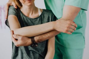 Nurse helping patient stretch shoulder